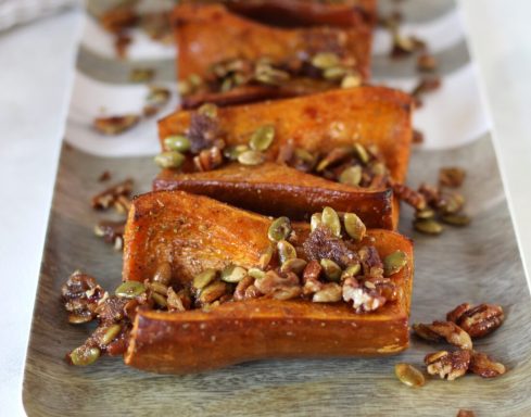 Baked sweet potato slices topped with crunchy pumpkin seeds and spices.